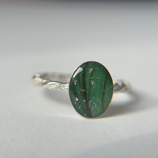 Emerald keepsake memorial ring with emerald color and silver flakes and twisted band