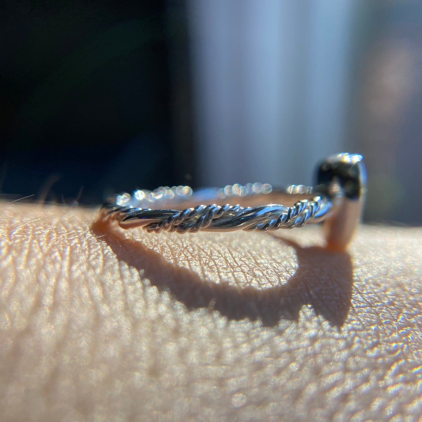 Close-up of a silver ring on a person's finger with a blurred background