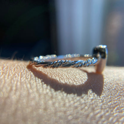 Close-up of a silver ring on a person's finger with a blurred background